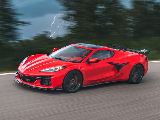 a red sports car driving down a road